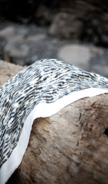 Carley Kahn "Stripe" upholstery fabric. Fabric in blue and tan colorway is draped over log.