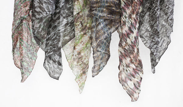 Carley Kahn silk scarves. Six of them hanging against white backdrop. 